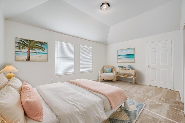 bedroom featuring light colored carpet, baseboards, and lofted ceiling