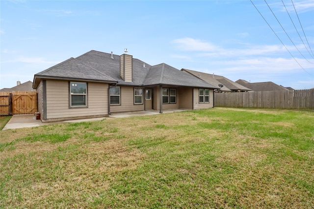 rear view of property featuring a yard and a patio area