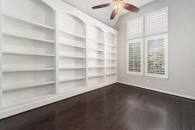 spare room with dark hardwood / wood-style floors, vaulted ceiling, and ceiling fan