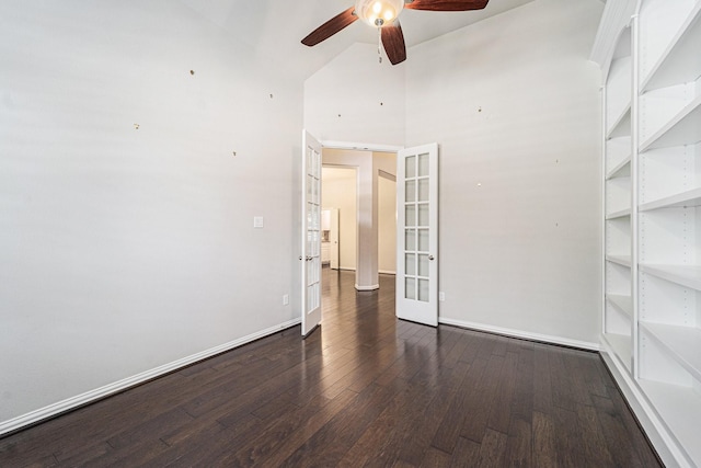 empty room with french doors, dark hardwood / wood-style floors, high vaulted ceiling, and ceiling fan