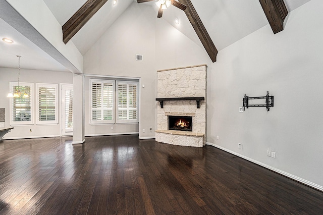 unfurnished living room featuring high vaulted ceiling, ceiling fan, a fireplace, beam ceiling, and dark hardwood / wood-style flooring