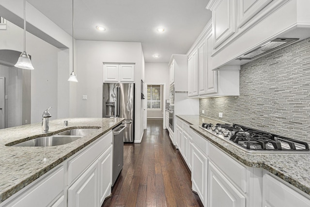 kitchen featuring white cabinetry, sink, decorative light fixtures, and appliances with stainless steel finishes