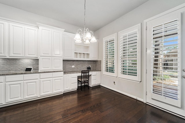 interior space with white cabinets, decorative backsplash, a healthy amount of sunlight, and hanging light fixtures