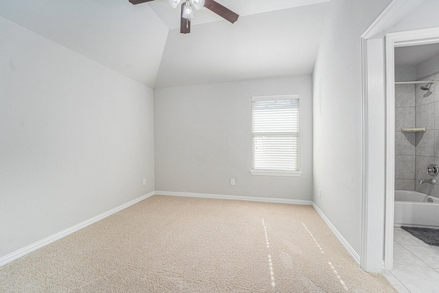 unfurnished bedroom with lofted ceiling, ensuite bathroom, ceiling fan, and light colored carpet