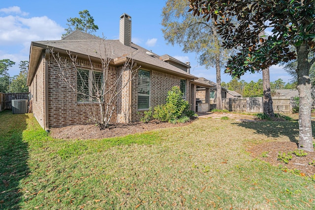 back of house with central AC and a yard