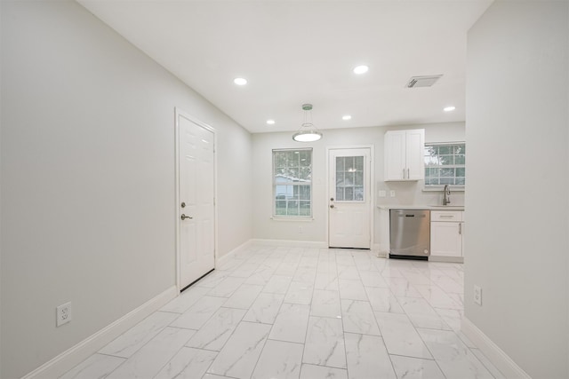 kitchen with dishwasher, white cabinets, sink, a wealth of natural light, and decorative light fixtures