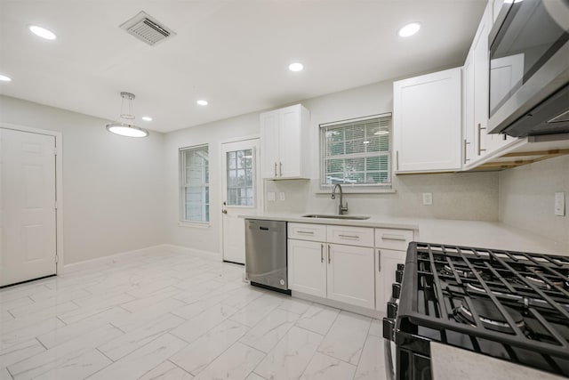 kitchen featuring white cabinets, decorative light fixtures, stainless steel appliances, and sink