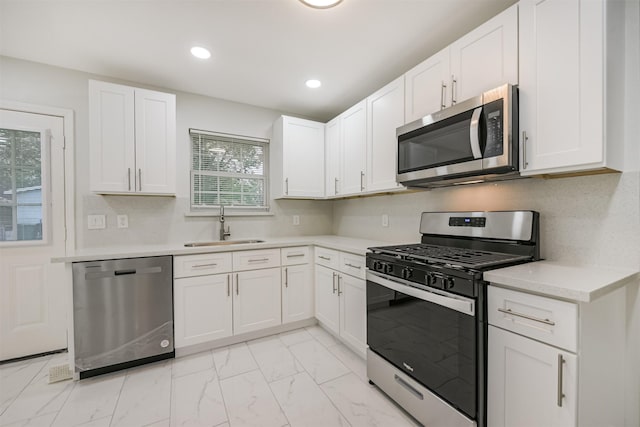 kitchen featuring backsplash, sink, white cabinets, and stainless steel appliances