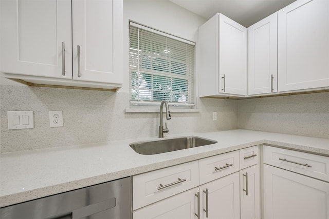 kitchen with light stone countertops, backsplash, beverage cooler, sink, and white cabinets