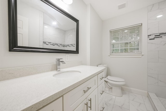 bathroom with a shower, vanity, and toilet