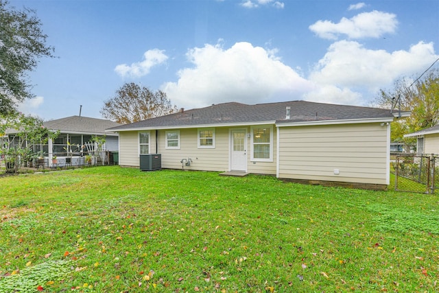 rear view of property featuring cooling unit and a yard