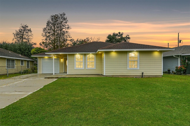 ranch-style house featuring a garage and a yard