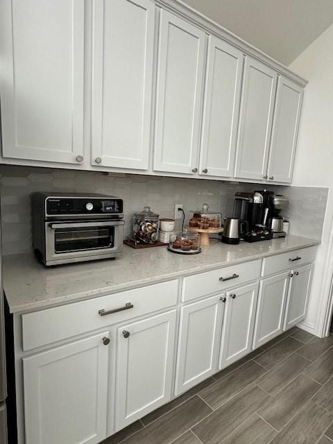 kitchen featuring tasteful backsplash and white cabinets