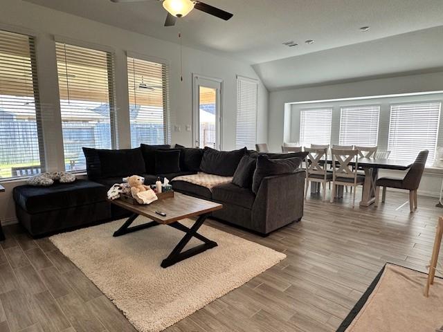 living room with ceiling fan and lofted ceiling