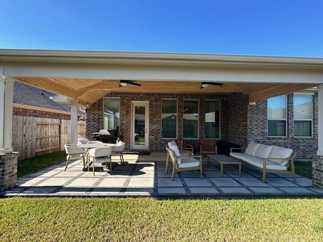 rear view of property featuring a lawn, ceiling fan, a patio area, and an outdoor living space