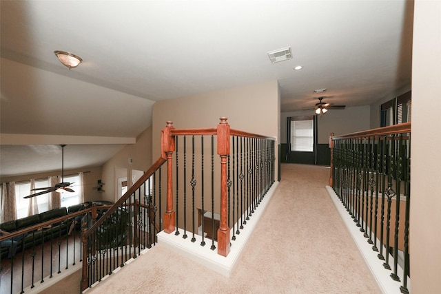 hallway with carpet and vaulted ceiling