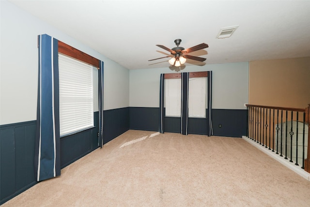 carpeted spare room with ceiling fan