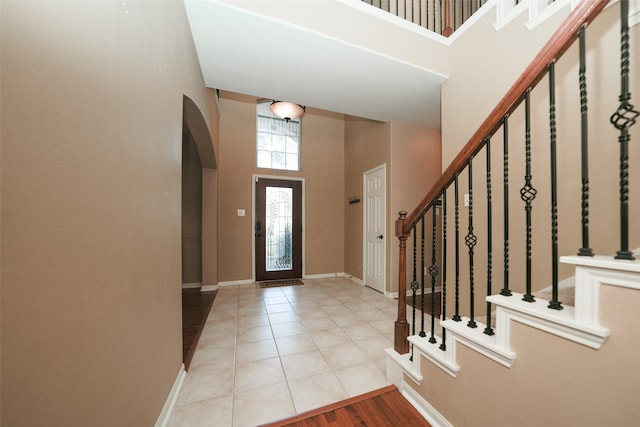 entryway featuring light tile patterned flooring and a high ceiling