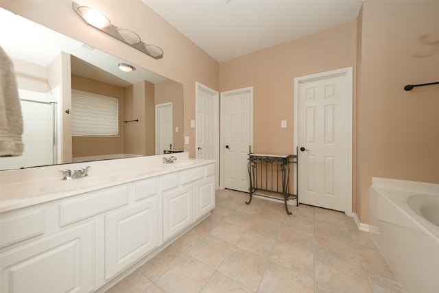 bathroom with a tub, tile patterned flooring, and vanity