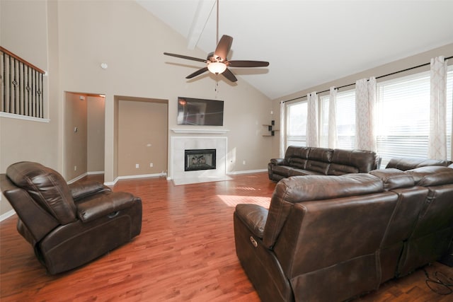 living room with a tile fireplace, hardwood / wood-style floors, high vaulted ceiling, and ceiling fan