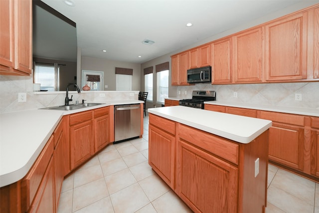 kitchen featuring backsplash, a kitchen island, sink, and appliances with stainless steel finishes