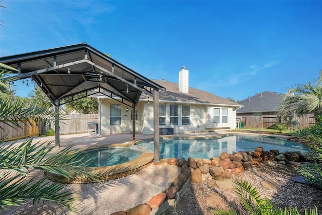 view of pool with an in ground hot tub