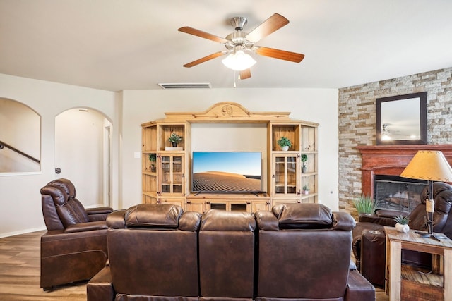 living room with ceiling fan, a fireplace, and hardwood / wood-style flooring