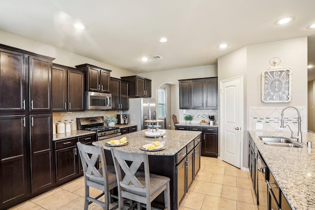 kitchen featuring light tile patterned flooring, stainless steel appliances, tasteful backsplash, and sink