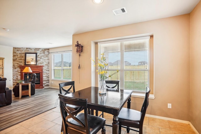 tiled dining area with a large fireplace