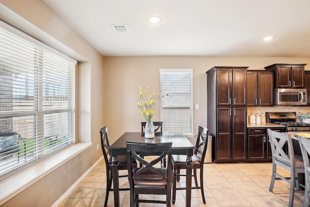 dining room with light tile patterned flooring and a wealth of natural light