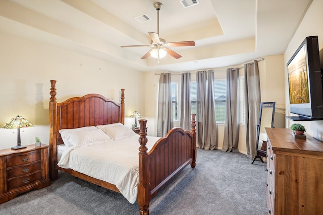 carpeted bedroom featuring a raised ceiling and ceiling fan