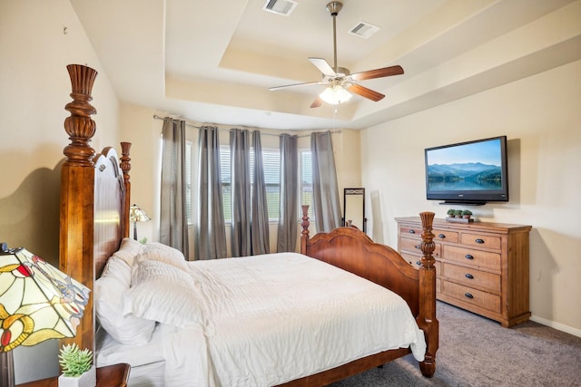 bedroom with a tray ceiling, ceiling fan, and light colored carpet