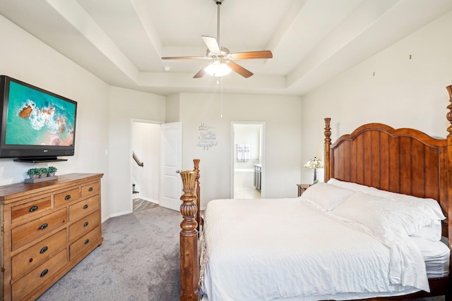 bedroom featuring carpet, ceiling fan, a raised ceiling, and connected bathroom