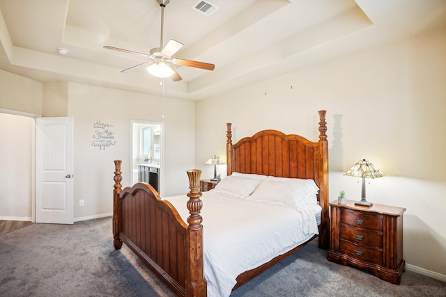 bedroom with carpet floors, ensuite bathroom, a raised ceiling, and ceiling fan