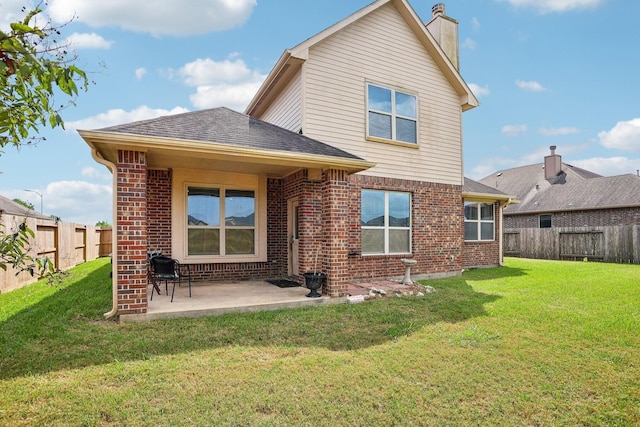 rear view of house with a lawn and a patio