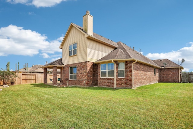 rear view of property featuring a lawn