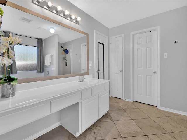 bathroom with tile patterned floors, a shower, and vanity