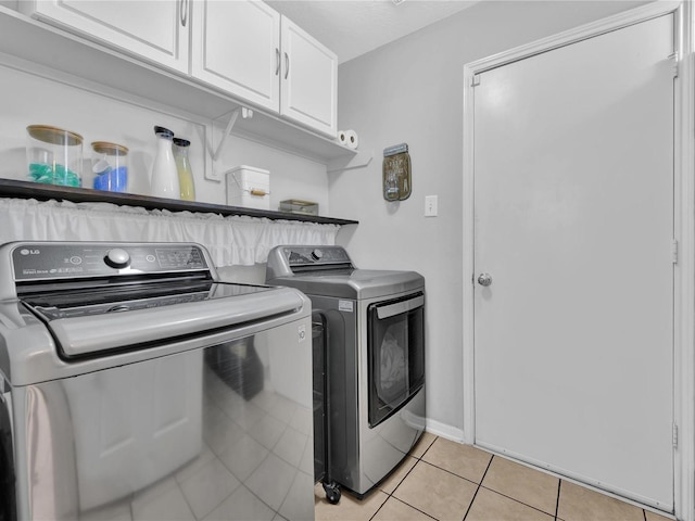 laundry room with cabinets, separate washer and dryer, and light tile patterned flooring