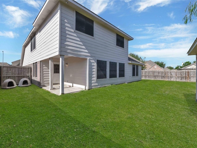 rear view of property featuring a patio and a lawn