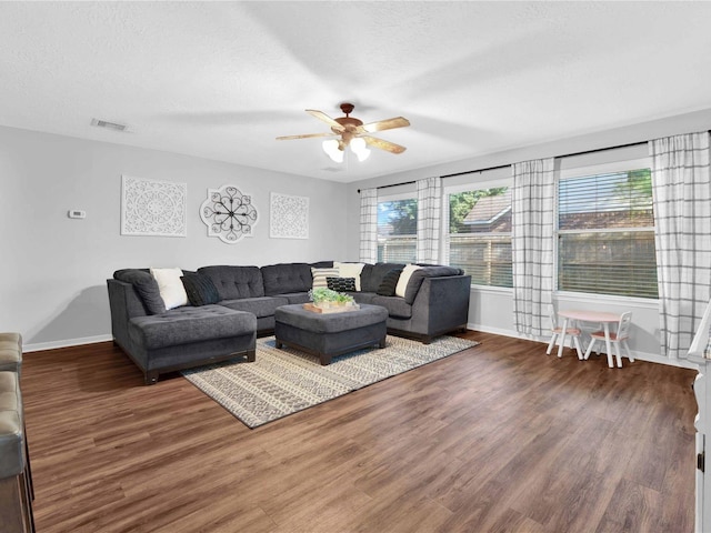 living room with hardwood / wood-style flooring, ceiling fan, and a textured ceiling