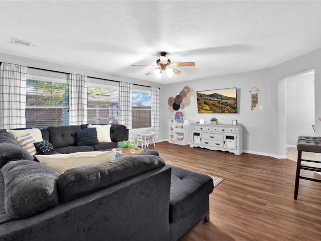 living room featuring a textured ceiling, dark hardwood / wood-style flooring, and ceiling fan