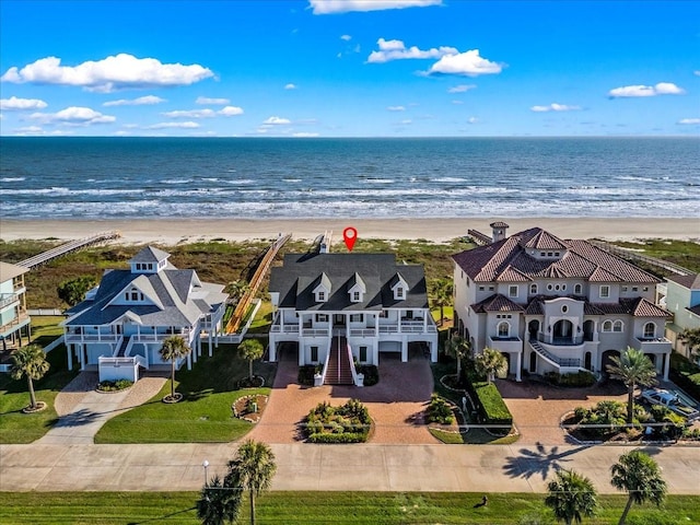 birds eye view of property with a water view and a beach view