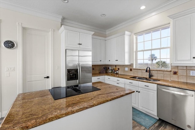 kitchen with dark hardwood / wood-style flooring, stainless steel appliances, sink, dark stone countertops, and white cabinets