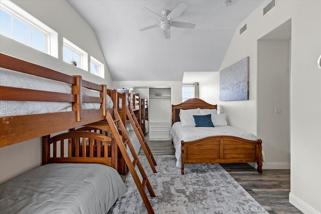 bedroom with multiple windows, ceiling fan, a closet, and dark hardwood / wood-style floors