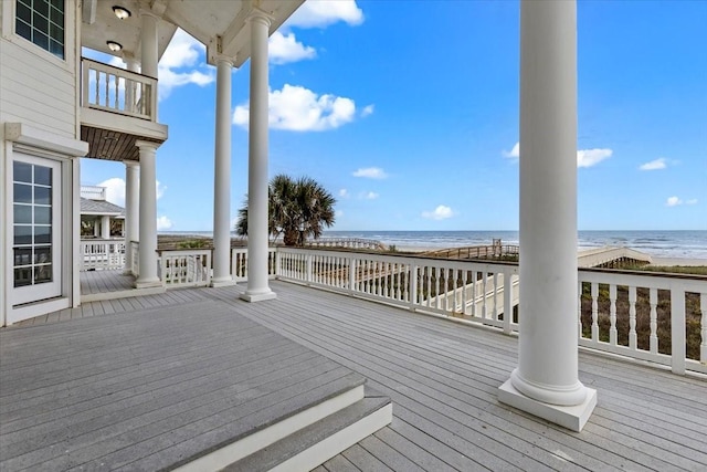 deck featuring a beach view and a water view