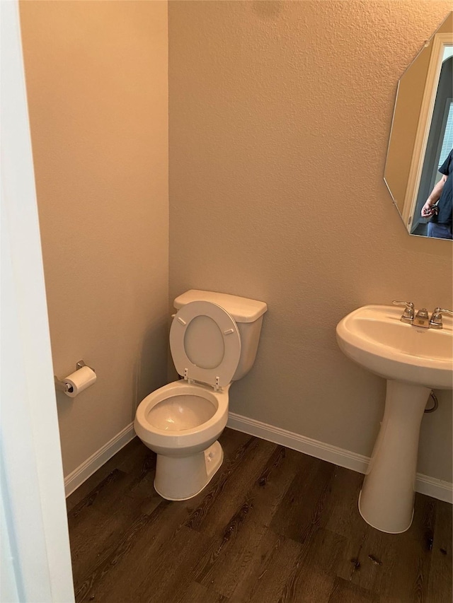 bathroom with toilet and wood-type flooring