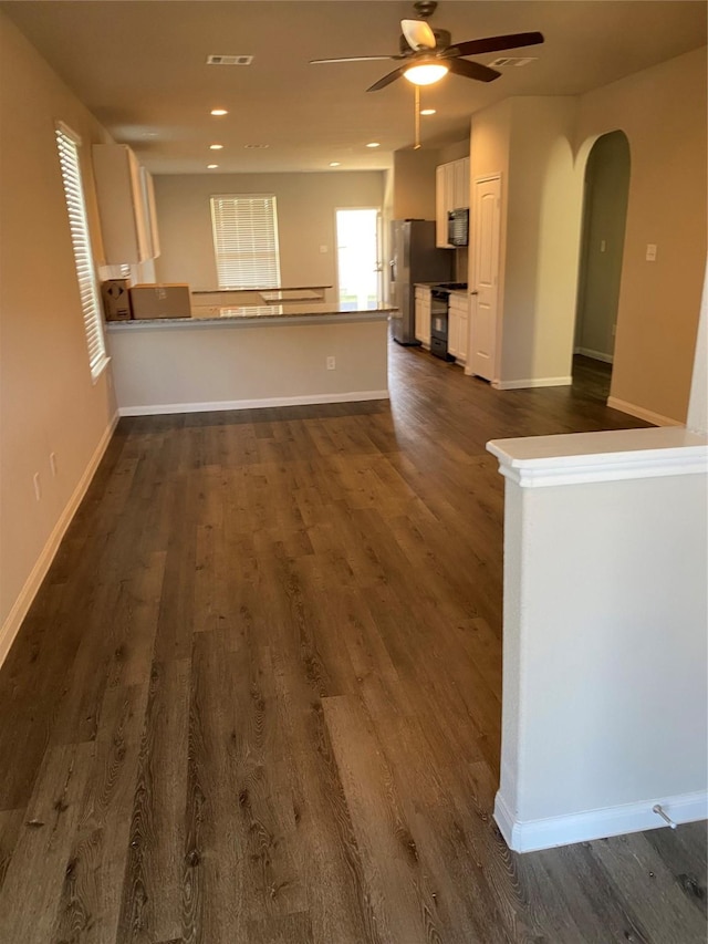 unfurnished living room featuring ceiling fan and dark hardwood / wood-style flooring