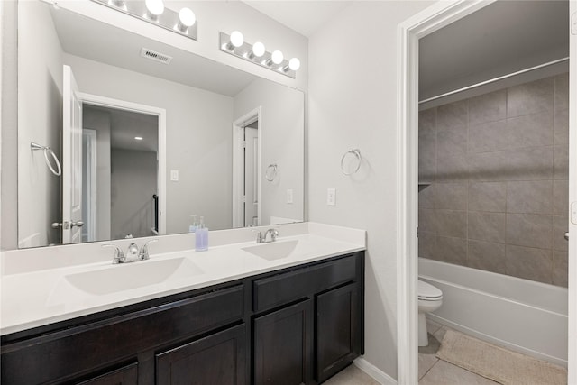 full bathroom featuring tile patterned flooring, vanity, tiled shower / bath combo, and toilet