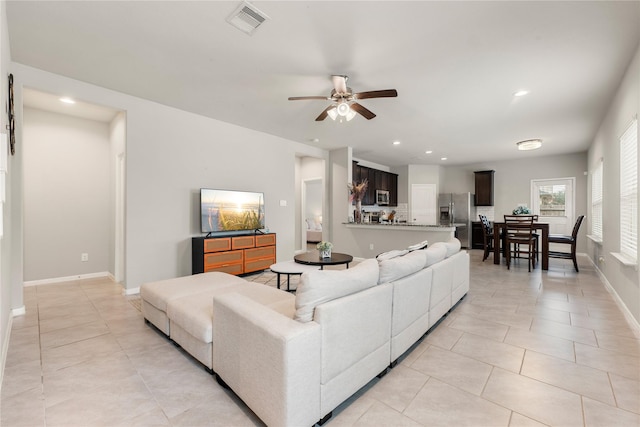 tiled living room with ceiling fan