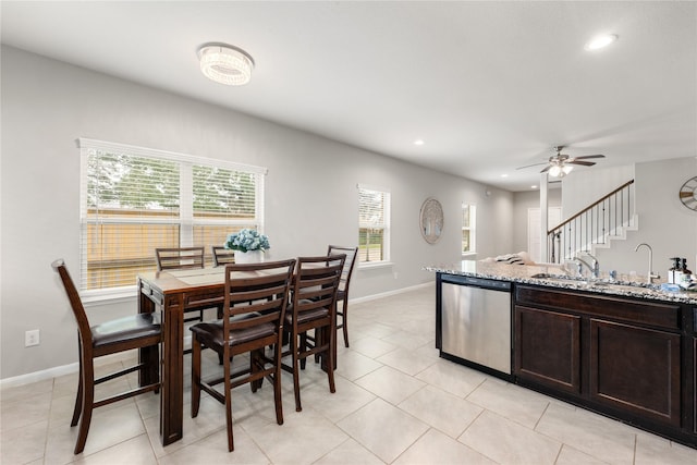 kitchen with sink, stainless steel dishwasher, ceiling fan, dark brown cabinets, and light stone counters